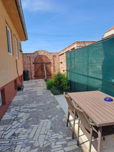 a patio with a wooden table and chairs and a building at Jiřinka in Vracov