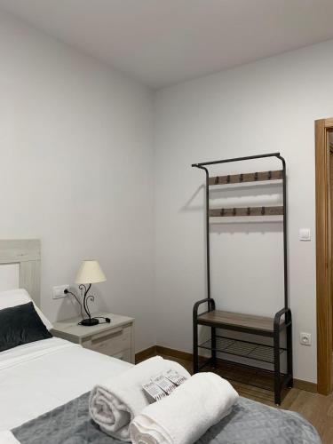 Dormitorio blanco con cama y estante en Castiñeiras Street 2, en Sarria