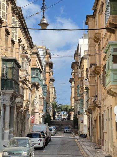 a city street with cars parked on the sides of buildings at Valletta Waterfront 2 Beds Flat by ArcoBnb in Il-Furjana