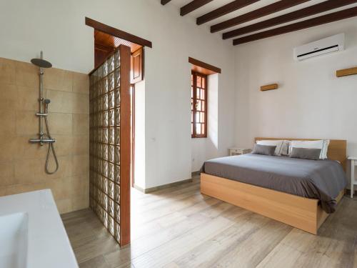 een slaapkamer met een bed en een badkamer met een bad bij Beautiful beach house in traditional Canarian style in Puerto de Mogán