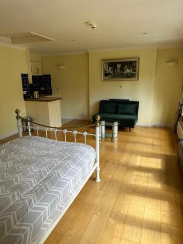 a bedroom with a bed and a couch in it at Maywoods Apartment in Virginia Water