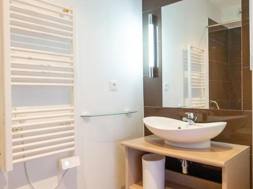 une salle de bain blanche avec un lavabo et un miroir dans l'établissement Studio confortable avec piscine, sauna, parking et animaux admis à Jausiers - FR-1-165B-40, à Jausiers