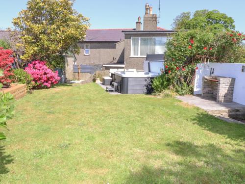a backyard with a yard with a stove at Tan Parc in Pwllheli