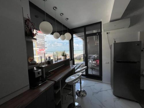 a kitchen with a counter and a refrigerator and a stool at Lavand Eighteen 3 in Mamaia Nord