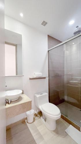 a bathroom with a toilet and a sink and a shower at Hotel MS Pacifico Chipichape in Cali