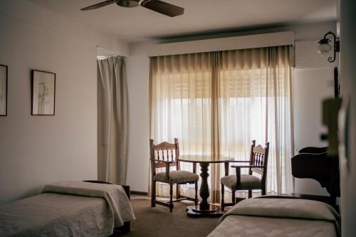 a bedroom with a table and chairs and a window at Gran Hotel Las Lajas in Villa Carlos Paz