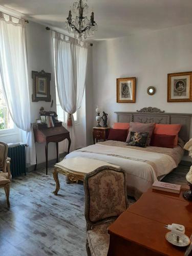 une chambre avec un lit, une table et un piano dans l'établissement La Villa des Remparts, à Labastide-dʼArmagnac