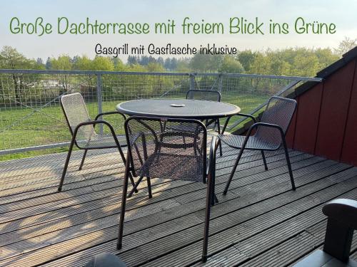 a table and chairs sitting on a deck at Studio - grosses Wohn-Schlafzimmer - Dachterrasse - Kamin - Küche - Hohes Venn - Monschau - Eifel - Hunde willkommen beim Hof Vierzehnender in Monschau