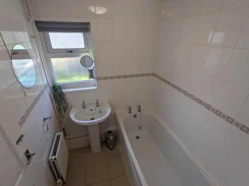 y baño con lavamanos, bañera y lavamanos. en No 51 - Spacious 3 Bed Home - Free Parking - Wi-Fi - Contractors, en West Derby