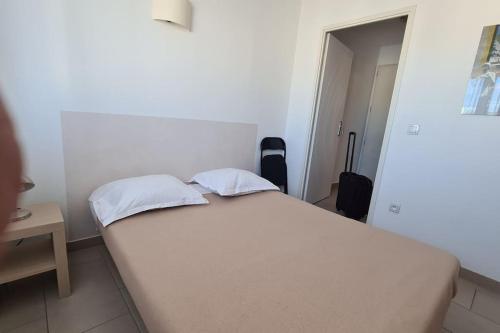 ein Schlafzimmer mit einem großen weißen Bett mit zwei Kissen in der Unterkunft Studio Cosy Perpignan 315 in Perpignan