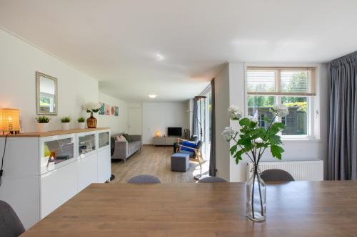 una cucina e un soggiorno con tavolo e sala da pranzo di Inlaag 20 a Wolphaartsdijk