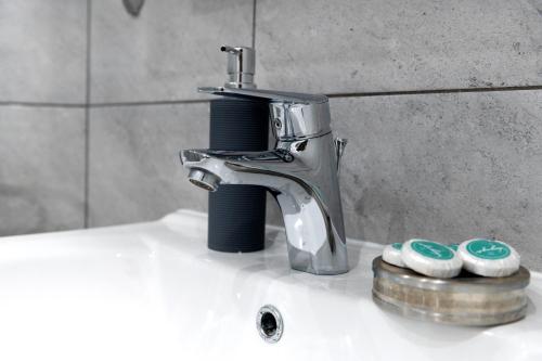a faucet sitting on top of a bathroom sink at Turkus Holiday in Pobierowo