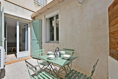 une table et des chaises vertes sur la terrasse dans l'établissement L'Olivier - 2 terrasses - Clim AC - WIFI - PROCHE THEATRES, à Avignon