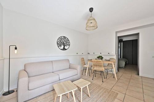 een woonkamer met een bank en een tafel bij L'Olivier - 2 terrasses - Clim AC - WIFI - PROCHE THEATRES in Avignon