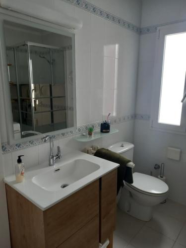 ein Badezimmer mit einem Waschbecken, einem WC und einem Spiegel in der Unterkunft Appartement Ferrera Park 408 vue mer in Cala Ferrera