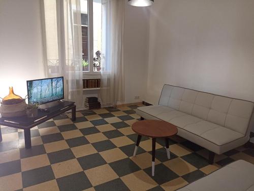 een woonkamer met een bank en een tafel bij hébergement de la plage en ville in Martigues