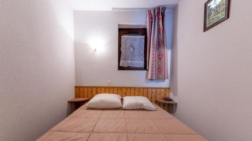 een kleine kamer met een bed met 2 kussens bij Grand Morillon 116 - Appt pied des pistes - 5 pers in Morillon