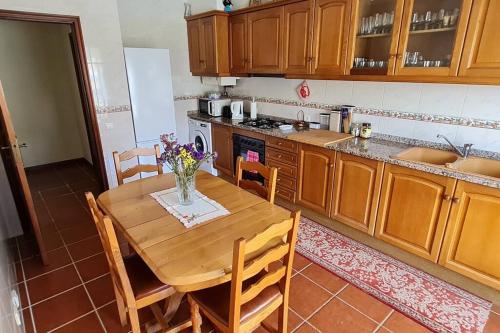 a kitchen with a wooden table with a vase of flowers on it at Lovely Modern Duplex 3 Bedroom Flat in Quiet Area in Tavarede
