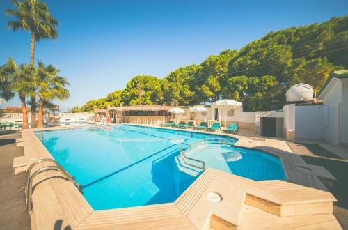 a large swimming pool next to a resort at Hotel PINE BAY CLUB & Cakistes Breakfast Restaurant next to popular Kervansaray beach in Kyrenia