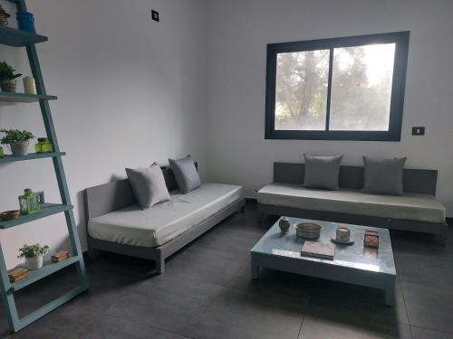 a living room with two couches and a table at The Green Blue House in Dar el Koudia
