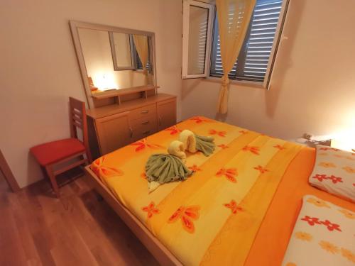una camera da letto con un letto con lenzuola gialle e uno specchio di Apartment Tonka a Mlini