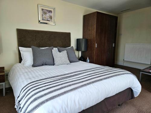 a bedroom with a large white bed with a brown headboard at The swan at compton in Compton