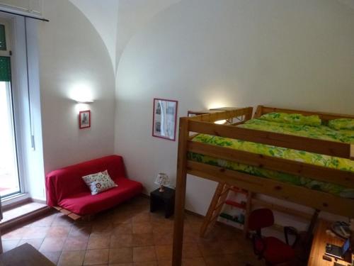 ローマにあるVacanze al Colosseo Polverieraのベッドルーム1室(二段ベッド1組、赤い椅子付)