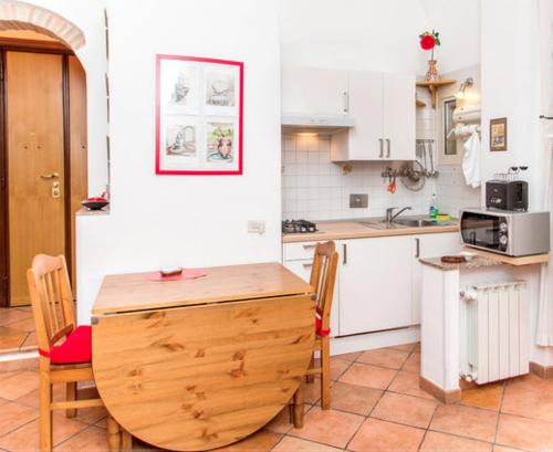 uma cozinha com uma mesa de madeira e cadeiras em Vacanze al Colosseo Polveriera em Roma
