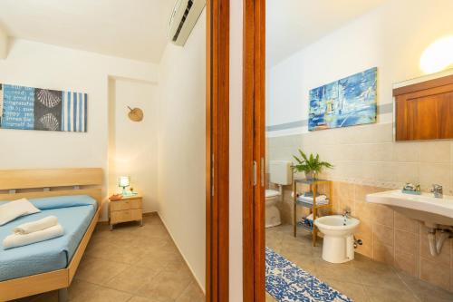a bathroom with a bed and a toilet and a sink at La casa di NONNO ELIGIO in Bari Sardo