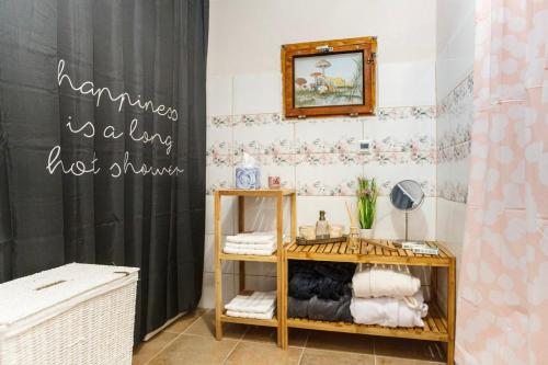 a bathroom with a black shower curtain and a shelf with towels at Chalupa Kámen in Pacov