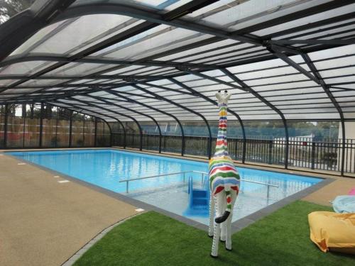 une grande piscine avec un toit en métal dans l'établissement MOBIL HOME 3 CHAMBRES N° 62 PARC ROSELIERES, à Saint-Hilaire-de-Riez