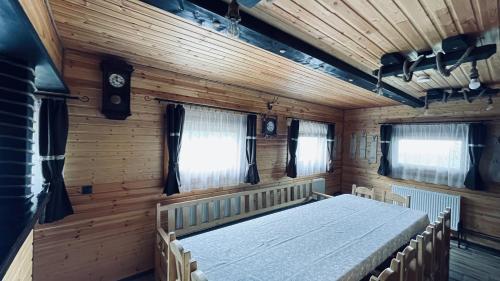 1 dormitorio con 1 cama en una habitación de madera en Cabana Niki-Rum Haz en Bucin