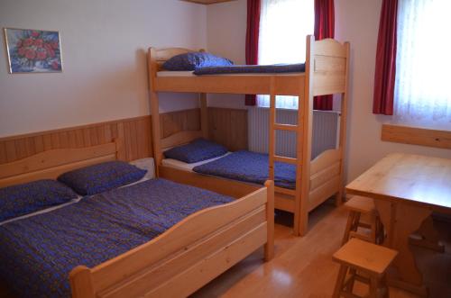 a room with three bunk beds and a desk at Apartmaji Srnca in Cerkno