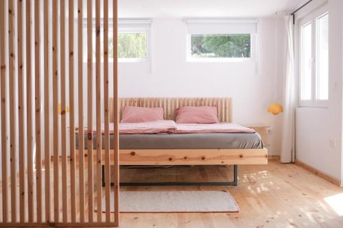 a bedroom with a bed with a wooden frame at Casa Mini & Casa Mia in Aljezur