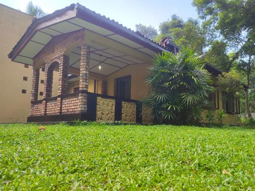 a house with a lawn in front of it at Cinnamon Villa in Ahungalla