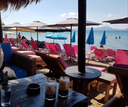 a group of chairs and umbrellas on a beach at Μοντέρνα εξοχική μονοκατοικία με ιδιωτική πισίνα! in Khalkoútsion