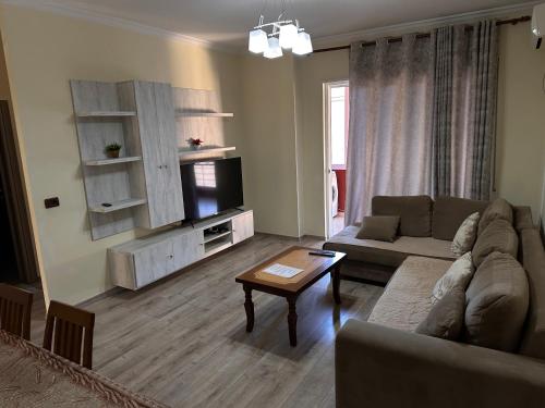 ein Wohnzimmer mit einem Sofa und einem Tisch in der Unterkunft Family Apartaments in Sarandë