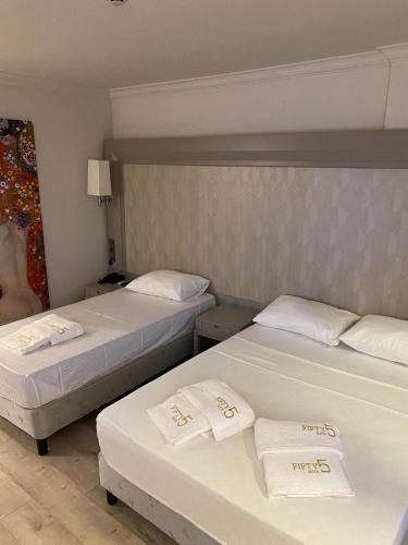 two beds in a hotel room with towels on them at FİFTY5 SUİTE HOTEL in Marmaris