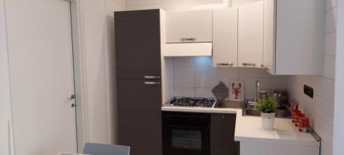 a kitchen with white cabinets and a stove top oven at Regina Margherita in Rimini