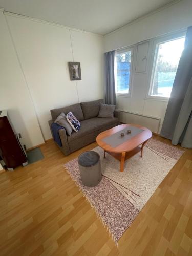 a living room with a couch and a coffee table at Parviainen-Helppoa yöpymistä in Soini
