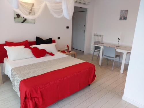 a bedroom with a red and white bed and a table at Regina Margherita in Rimini
