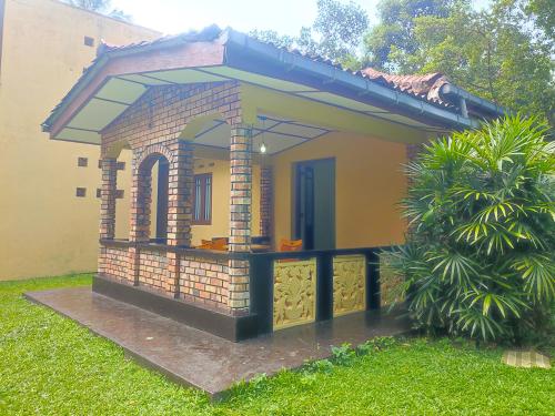 a small house with a porch in the yard at Cinnamon Villa in Ahungalla
