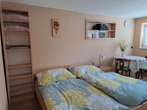 a bedroom with two beds and a table at Apartmán Store in Vracov