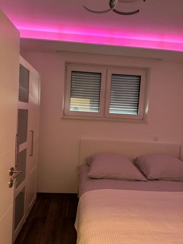 Schlafzimmer mit rosa Licht über einem Bett in der Unterkunft myhouse.5 in Eppelheim