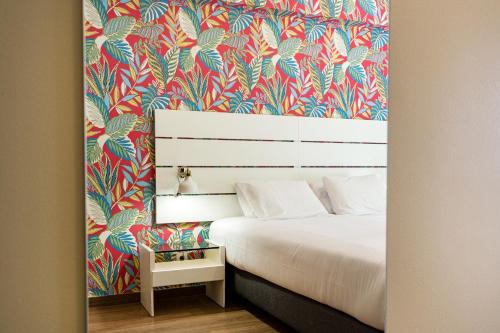 a bedroom with a bed with a colorful wallpaper at DOME Alvares Cabral in Lisbon
