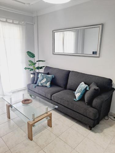 uma sala de estar com um sofá e uma mesa de vidro em CANELA em Playa de San Juan