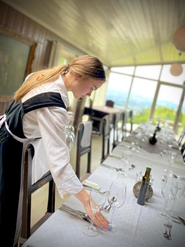 a woman standing at a table with wine glasses at Kleivstua Hotel near Krokskogen in Sundvollen