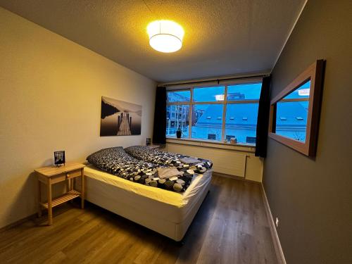 ein Schlafzimmer mit einem Bett und einem großen Fenster in der Unterkunft Johann´s Guesthouse in Reykjavík