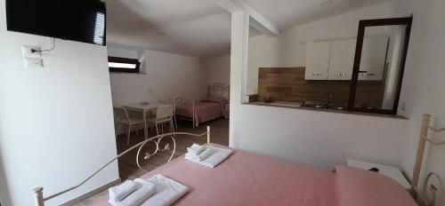 1 dormitorio con cama rosa y espejo en Arena Vacanze en Castellabate
