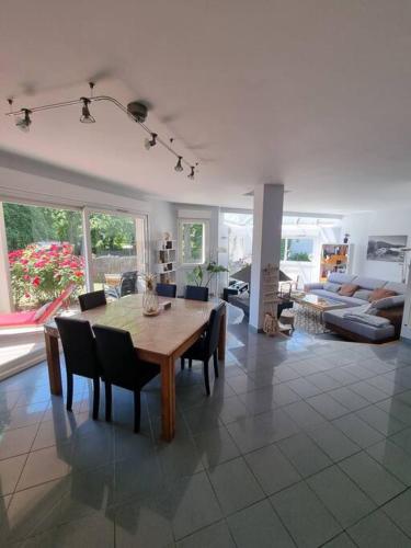 un salon avec une table et des chaises en bois dans l'établissement Charmante maison proche de Paris, à Sainte-Geneviève-des-Bois